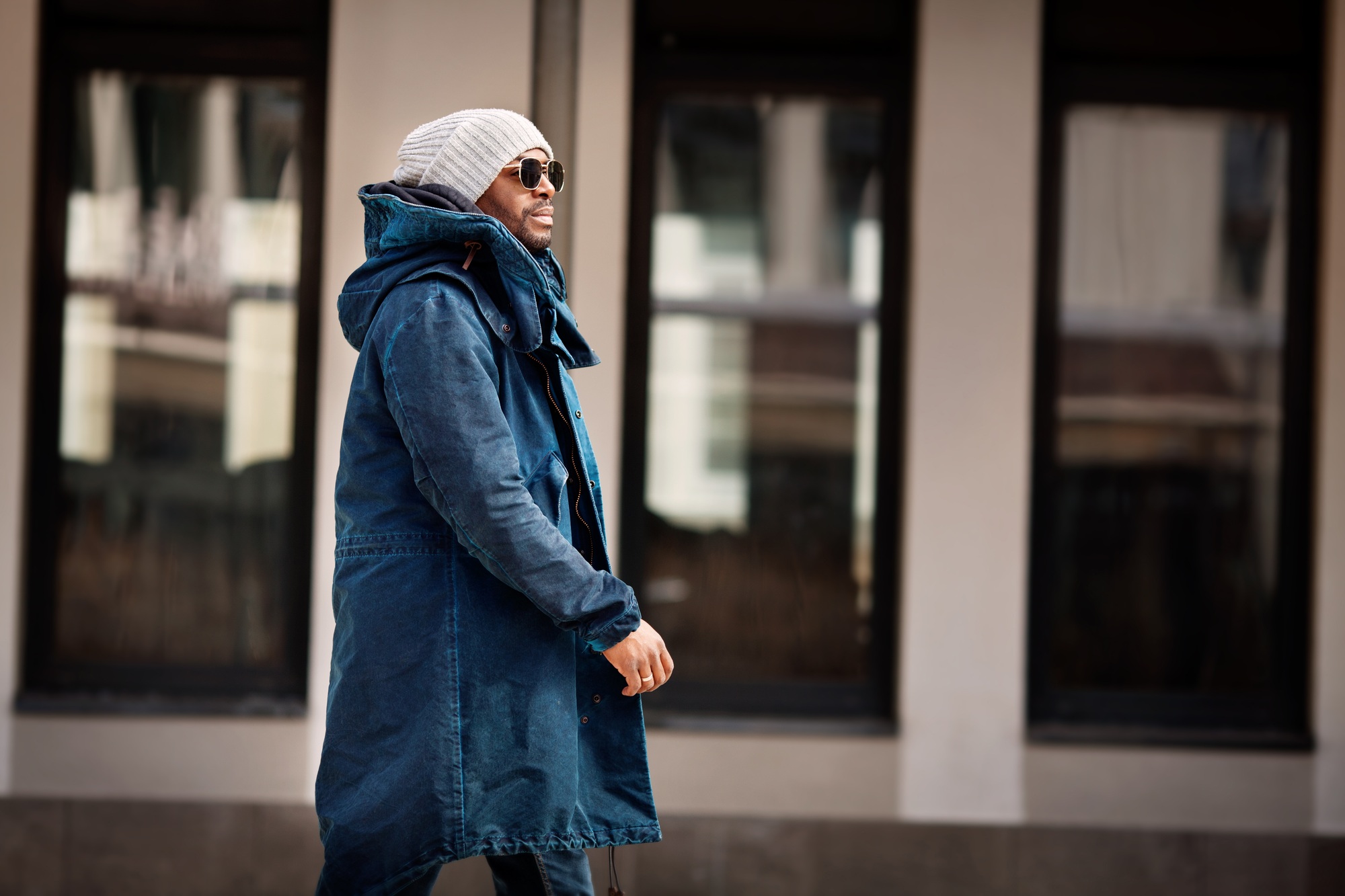 Portrait of handsome African American man walking in city, wearing stylish outfit parka coat