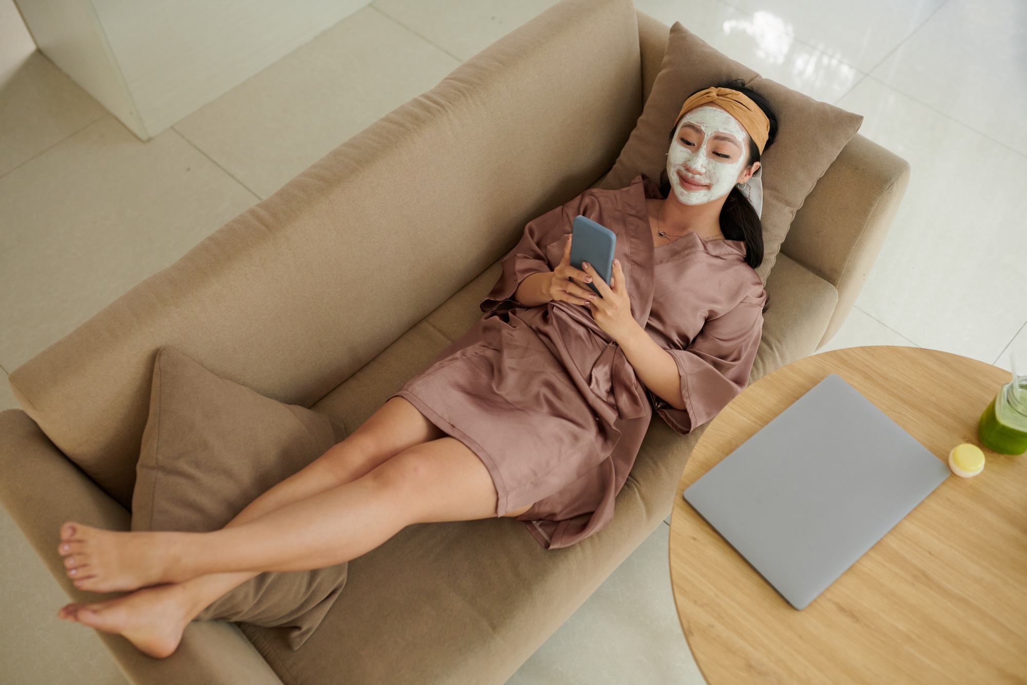 Woman Relaxing on Couch with Face Mask on
